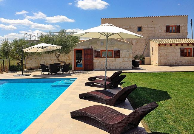 Photo de la maison avec piscine et chaises longues sur la pelouse